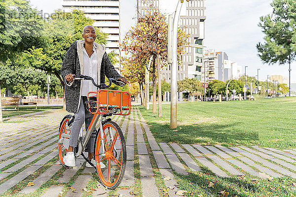 Geschäftsfrau  die mit dem Fahrrad in der Stadt unterwegs ist