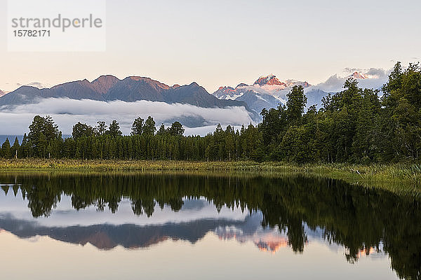 Neuseeland  Westland-Distrikt  Fox Glacier  Lake Matheson spiegeln umliegenden Wald und entfernte Bergkette wider