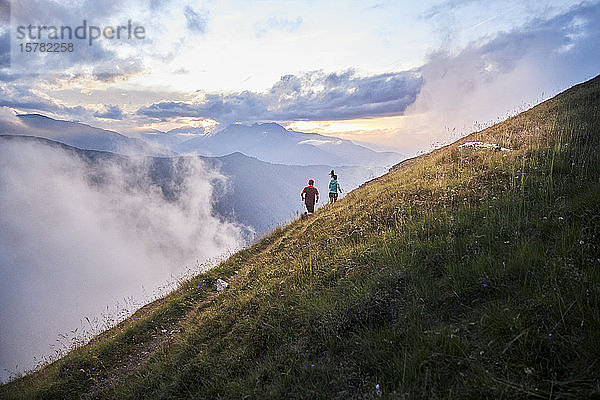 Mann und Frau laufen in den Bergen bergauf