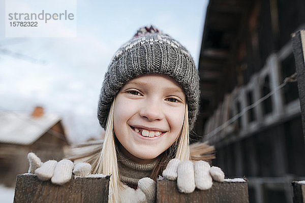 Porträt eines glücklichen Mädchens mit Wollmütze im Winter