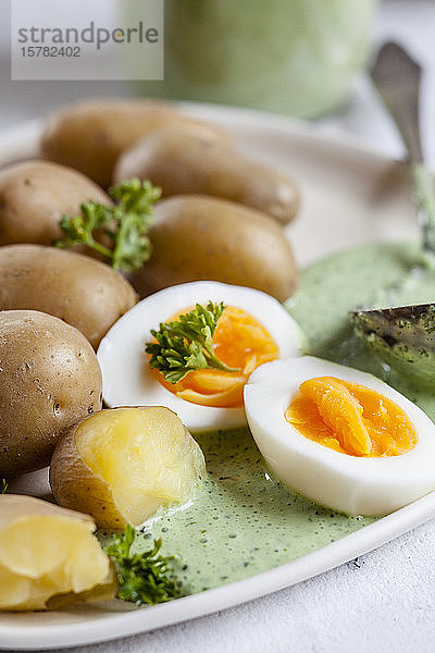Kartoffelteller mit gekochten Eiern  Petersilie und Salsa-verde-Sauce
