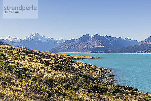 Neuseeland  klarer Himmel über dem türkisfarbenen Ufer des Pukaki-Sees mit Mount Cook im Hintergrund