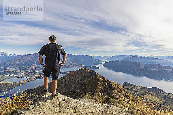 Wanderer steht auf dem Aussichtspunkt am Roys Peak mit Blick auf den Mount Aspiring  Lake Wanaka  Südinsel  Neuseeland