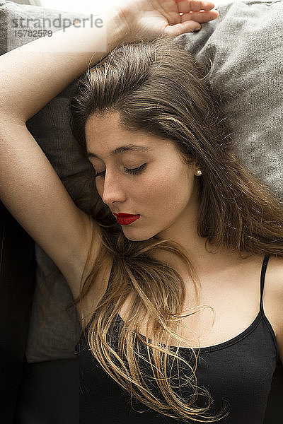 Porträt einer schlafenden jungen Frau mit roten Lippen