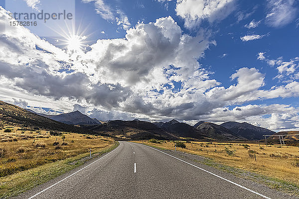Neuseeland  Bealey  Wolken über dem leeren State Highway 73 mit Bergen im Hintergrund