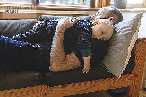 Vater und Sohn schlafen zusammen auf dem Sofa