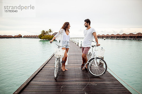 Paar mit Fahrrädern auf einem Steg im Meer  Insel Maguhdhuvaa  Gaafu-Dhaalu-Atoll  Malediven