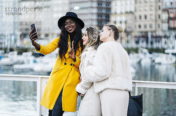 Freundinnen beim Selfie im Yachthafen der Stadt