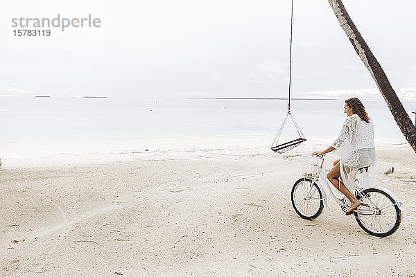 Frau fährt Fahrrad am Strand  Insel Maguhdhuvaa  Gaafu-Dhaalu-Atoll  Malediven