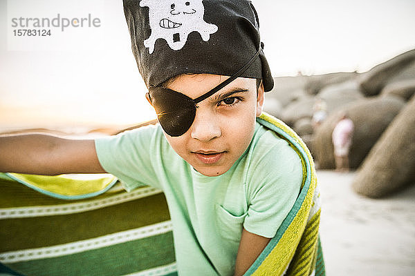 Porträt eines als Pirat verkleideten Jungen am Strand