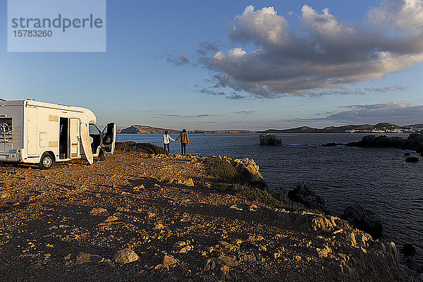 Rückansicht eines Paares  das die Aussicht Hand in Hand genießt  Es Mercadal  Menorca  Spanien