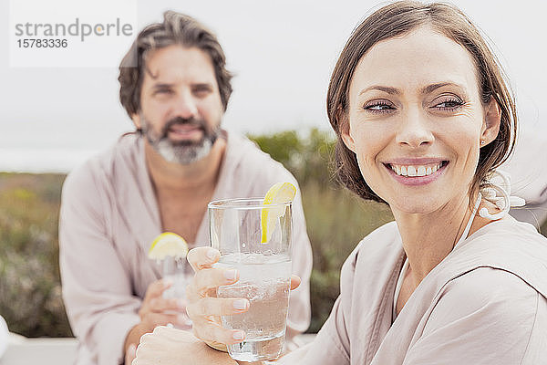 Glückliches  entspanntes Paar mit Drinks auf der Terrasse