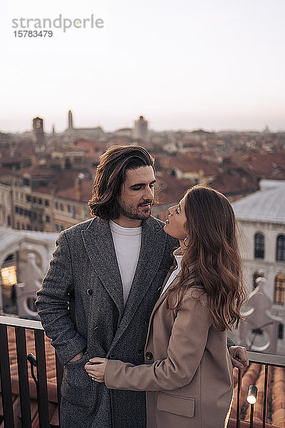 Zärtliches junges Paar auf einem Balkon über der Stadt Venedig  Italien