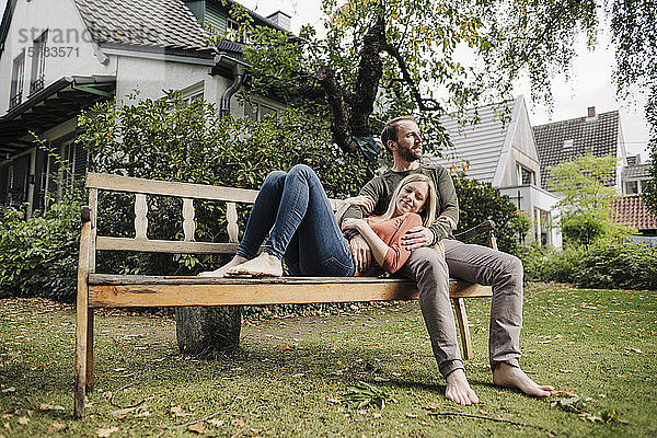 Ein Paar entspannt sich auf einer Bank und genießt die Natur in ihrem Garten