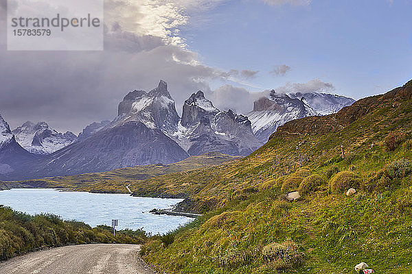 Chile  Provinz Ultima Esperanza  Leere Schotterstraße mit dem Pehoe-See und den Cuernos del Paine im Hintergrund