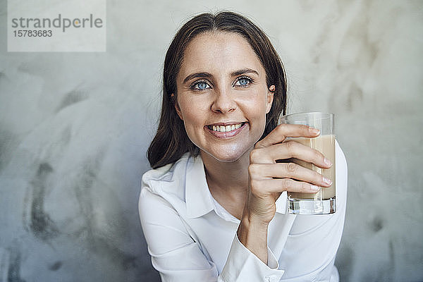 Porträt einer lächelnden Frau mit Glas in der Hand