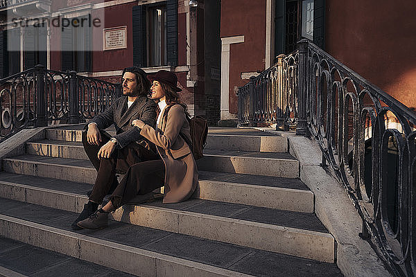 Junges Paar sitzt auf einer Brücke in der Stadt Venedig  Italien