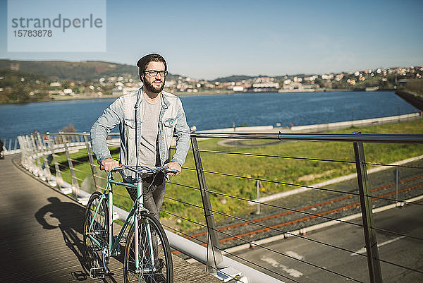 Junger Mann pendelt mit seinem Fixie-Rad in der Stadt