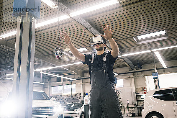 Automechaniker mit VR-Brille in einer Werkstatt