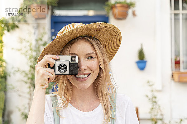 Porträt einer glücklichen jungen Frau mit Kamera