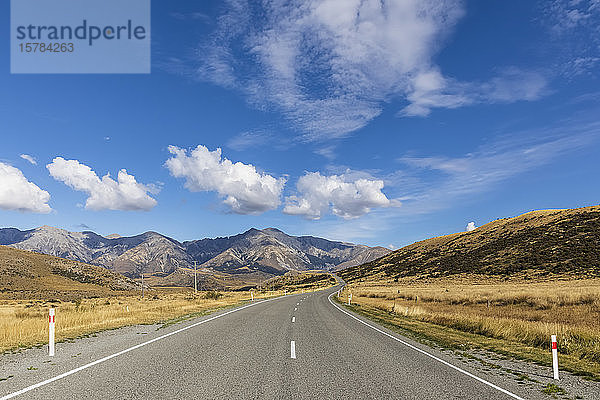 Neuseeland  Wolken über dem leeren State Highway 73 mit Bergen im Hintergrund