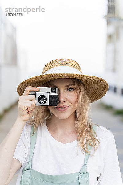 Porträt einer lächelnden jungen Frau mit Kamera