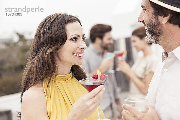 Ehepaar und Freunde treffen sich auf einer Cocktailparty