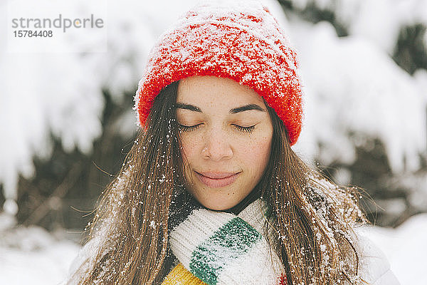 Porträt einer lächelnden Frau mit geschlossenen Augen im Winter