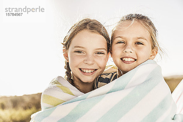 Porträt von zwei glücklichen  süßen Mädchen in ein Handtuch gewickelt