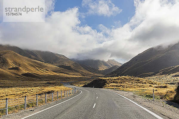 Neuseeland  Wolken über dem leeren State Highway 8 im Lindis Pass