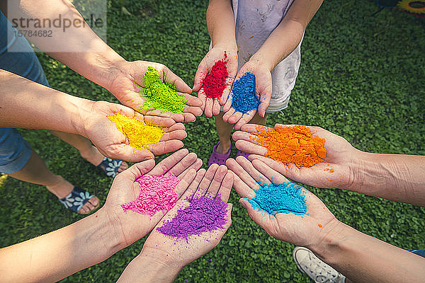 Kreis von Händen voller Pulverfarbe