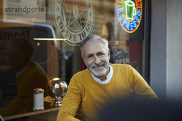 Porträt eines lächelnden reifen Mannes in einem Cafe