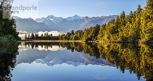 Neuseeland  Westland-Distrikt  Fox Glacier  Lake Matheson spiegeln umliegenden Wald und entfernte Bergkette wider