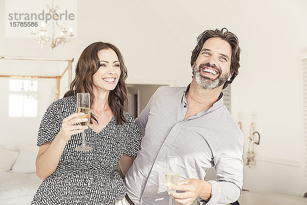 Glückliches Paar trinkt Champagner im Ferienhaus