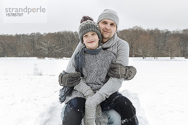 Porträt eines glücklichen Vaters mit diesem Sohn in Winterlandschaft