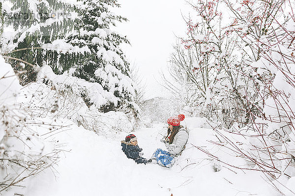 Frau spielt mit Baby in Winterlandschaft  Kanada