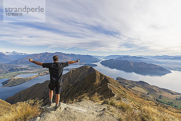 Wanderer steht auf dem Aussichtspunkt am Roys Peak mit Blick auf den Mount Aspiring  Lake Wanaka  Südinsel  Neuseeland