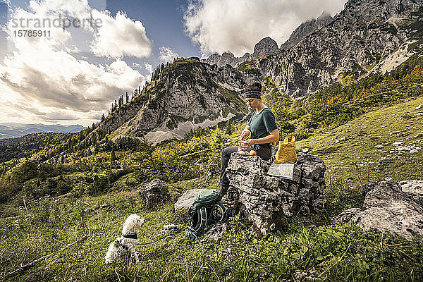 Frau mit Hund auf einer Wanderung am Wilden Kaiser bei einer Pause  Kaisergebirge  Tirol  Österreich