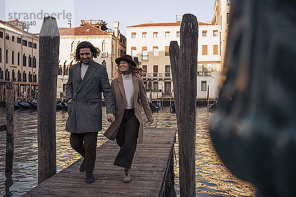 Junges Paar beim Spaziergang auf einem Steg am Canal Grande in Venedig  Italien