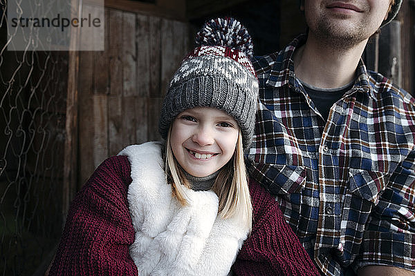 Porträt eines lächelnden Mädchens mit ihrem Vater im Winter im Freien