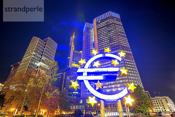 Deutschland  Hessen  Frankfurt  Niedrigwinkelansicht der Euro-Skulptur vor dem Eurotower bei Nacht