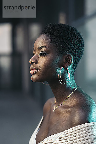 Porträt einer jungen Frau mit goldenen Ohrringen und Halskette