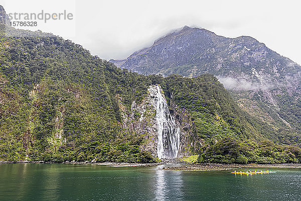 Neuseeland  Ozeanien  Südinsel  Southland  Fiordland National Park  Port of Milford Sound mit Bowen Falls und Barren Peak  Kanufahrer auf dem Wasser