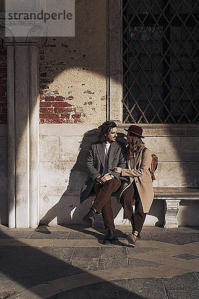 Junges Paar sitzt auf einer Bank in Venedig  Italien