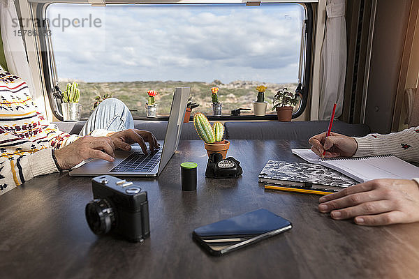 Schrägansicht eines in einem Wohnmobil arbeitenden Paares  Es Mercadal  Menorca  Spanien