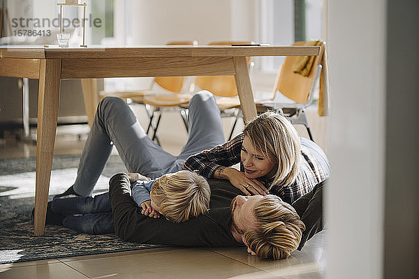 Glückliche  entspannte Familie  die zu Hause gemeinsam auf dem Boden liegt