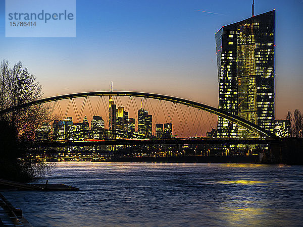 Deutschland  Hessen  Frankfurt  Frankfurt am Main Skyline hinter der Ostendbrücke und die Europäische Zentralbank in der Abenddämmerung