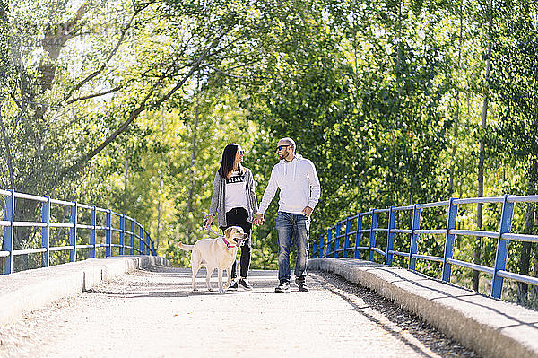 Ein Paar spielt mit seinem Hund in einem Park