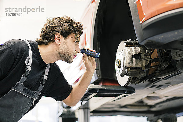 Automechaniker in einer Werkstatt bei der Arbeit am Auto
