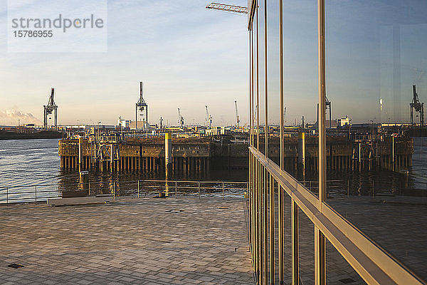 Deutschland  Hamburg  Fenster spiegeln HafenCity-Kräne in der Morgendämmerung